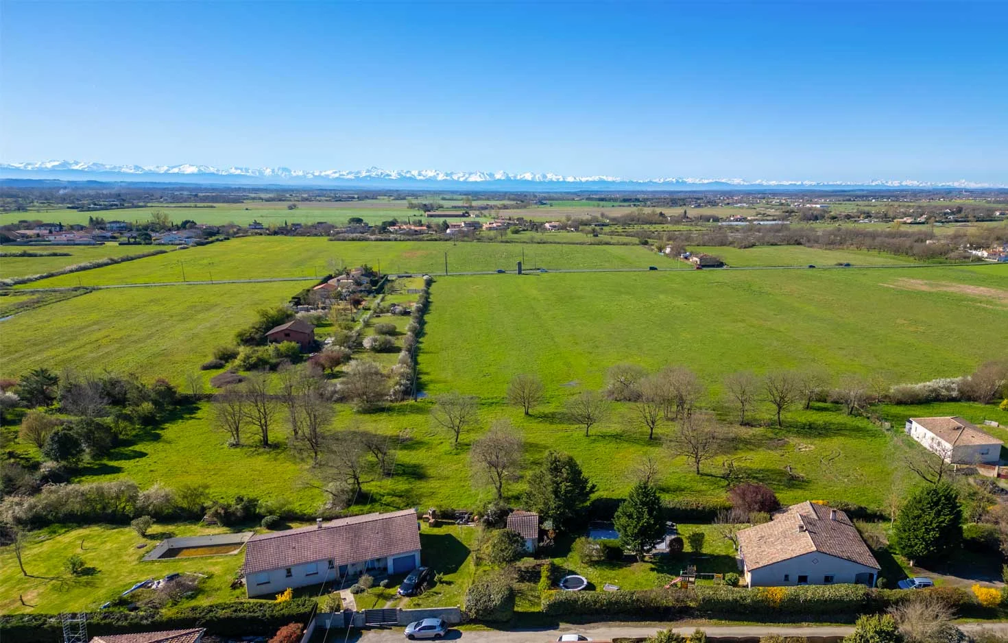 Vue aérienne du terrain du lotissement Fourtané à Seysses, Pyrénées en arrière-plan.